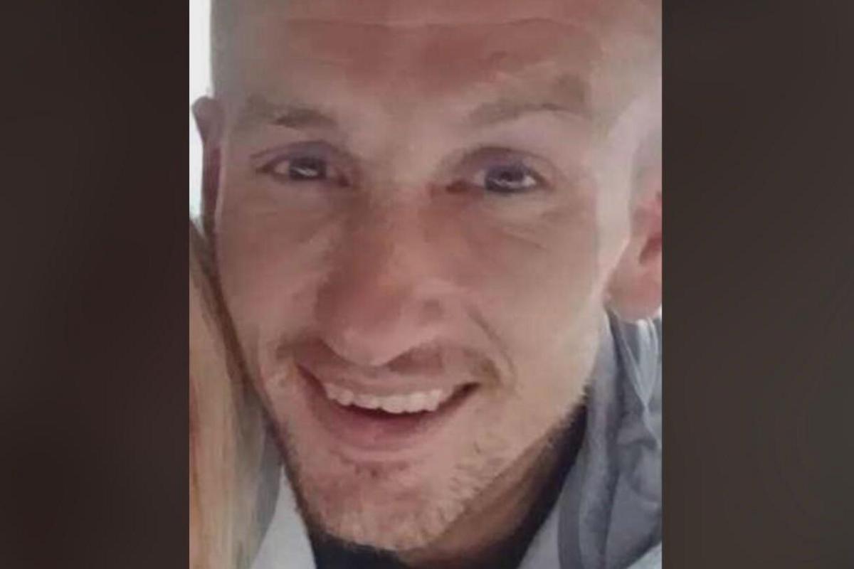 Close-up image of Michael O'Reilly. He is smiling at the camera and has a stubbly beard