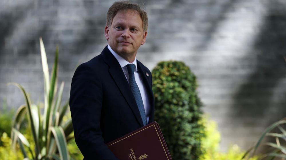 Sir Grant Shapps leaving Downing Street carrying a red folder 